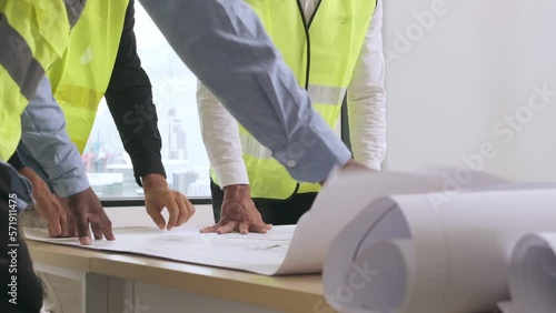 Architect and engineer person meeting with project design team at office looking blueprint construciton building plan for finish work.