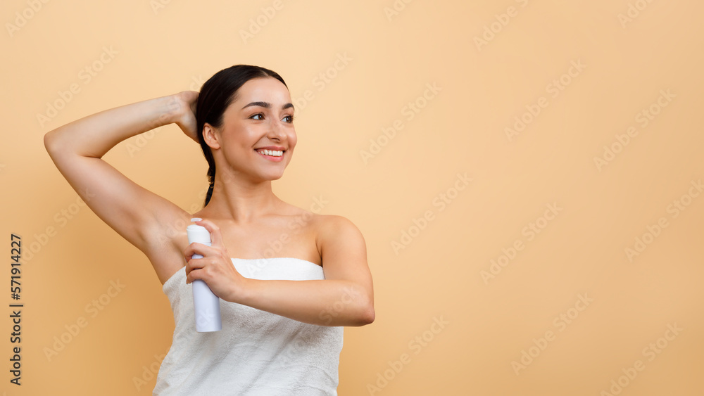 Portrait Of Smiling Young Indian Woman Using Deodorant Spray For Underarms Portrait Of Smiling Young Indian Woman Using Deodorant Spray For Underarms