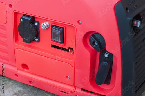 The red body of the electric gasoline generator from honda. Compact mobile voltage generator