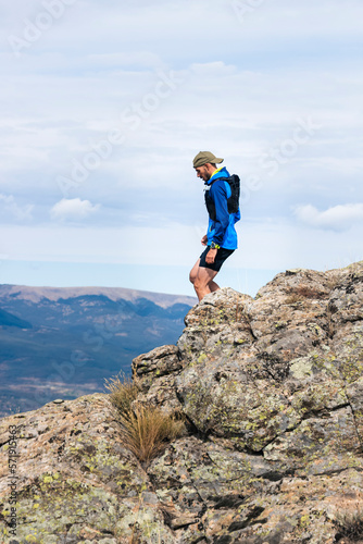 Young man practising trail running on a mountain top