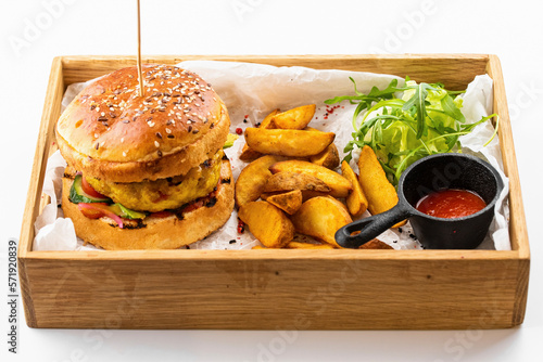 American chicken burger with potato wedges and tomato sauce photo