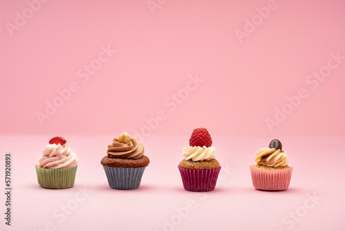Various mini cupcakes against a pink background