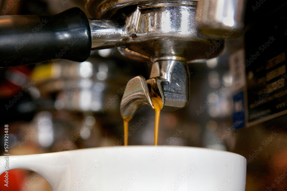Close-up of double espresso dripping into cup Close-up of double espresso dripping into cup