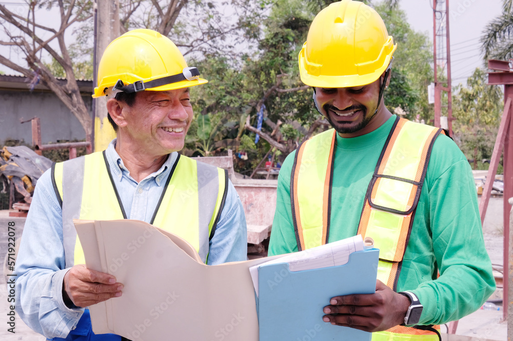 Male engineer in safety helmet inspecting construction drawings at construction site building construction concept. Male engineer in safety helmet inspecting construction drawings at construction site building construction concept.