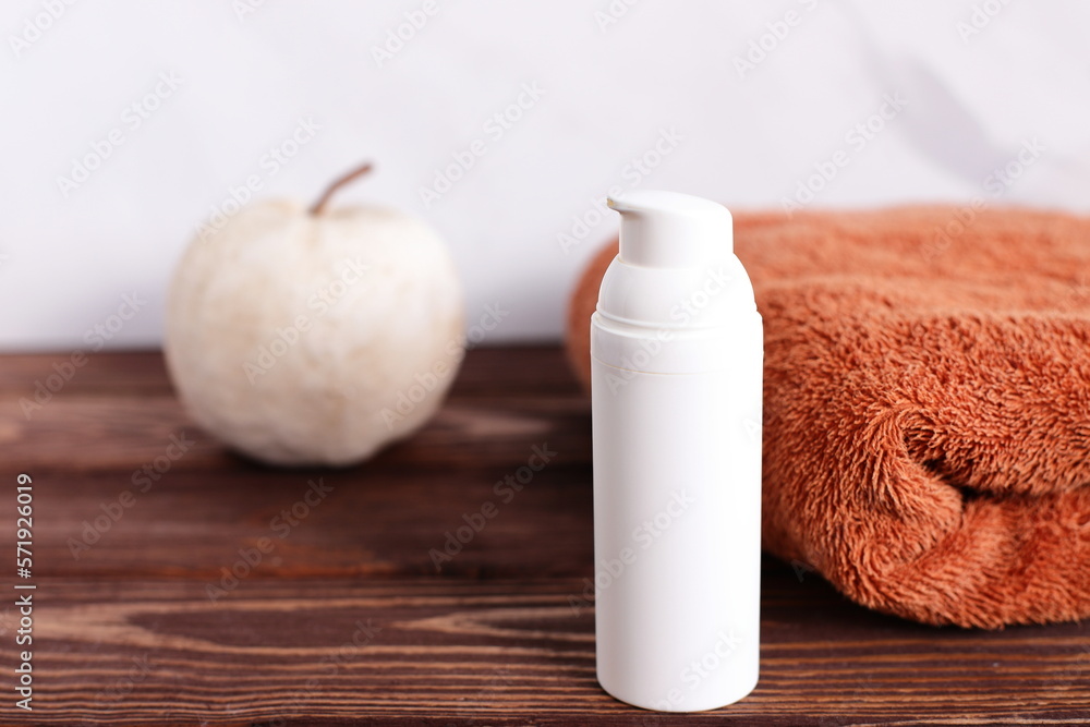 White cosmetic bottle mock up with towel on wooden table, bath lifestyle staging White cosmetic bottle mock up with towel on wooden table, bath lifestyle staging