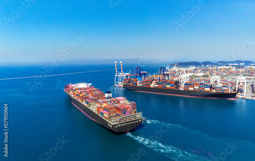 Arial view by drone camera transportation logistics and container dock cargo yard with working crane bridge in shipyard with transport logistic import export with blue sky background.