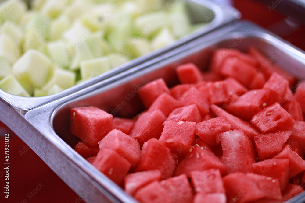 Fresh watermelon and honeydew melon served on buffet trays during party Fresh watermelon and honeydew melon served on buffet trays during party