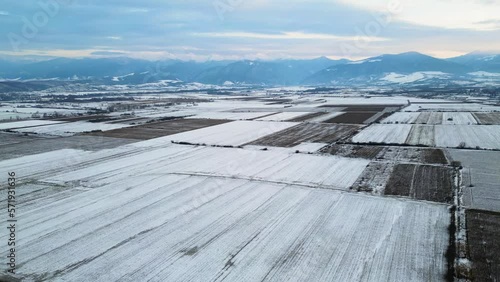 Drone flight over frozen field in vicinity of Retezat Mountains, Hunedoara county, Romania, Europe.