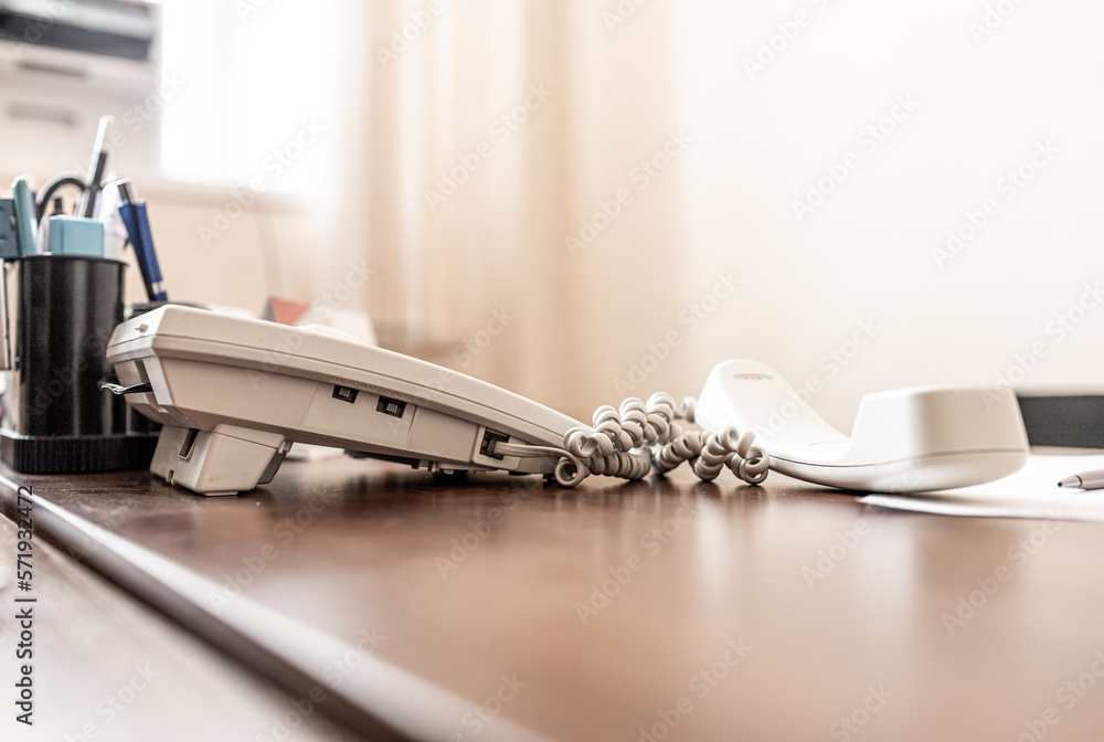 Office work, paperwork concept. Stationary, handset on the desk in the office. Wired phone on office table Office work, paperwork concept. Stationary, handset on the desk in the office. Wired phone on office table