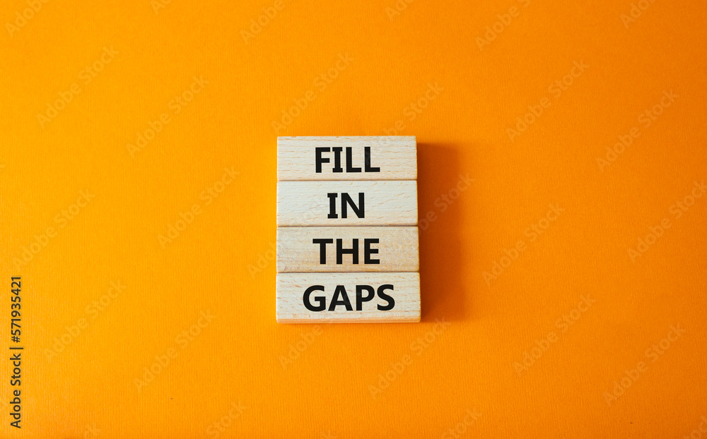 Fill in the gaps symbol. Concept words fill in the gaps on wooden blocks. Beautiful orange background. Business and fill in the gaps concept. Copy space. Fill in the gaps symbol. Concept words fill in the gaps on wooden blocks. Beautiful orange background. Business and fill in the gaps concept. Copy space.