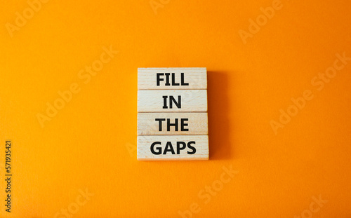 Fill in the gaps symbol. Concept words fill in the gaps on wooden blocks. Beautiful orange background. Business and fill in the gaps concept. Copy space.