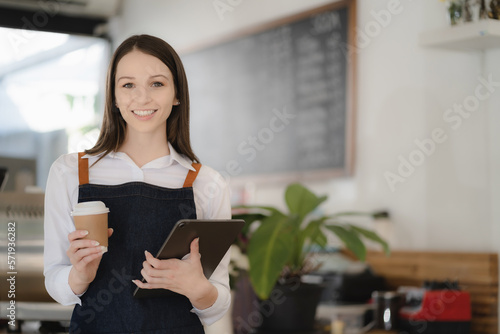 Coffee Business owner Concept - attractive young beautiful caucasian barista in apron smiling at camera in coffee shop counter.