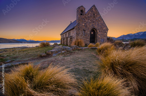 Old church on grassy shore of lake photo