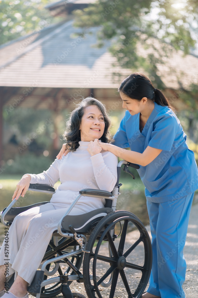 Happy patient is holding caregiver for a hand while spending time together outdoor. Happy patient is holding caregiver for a hand while spending time together outdoor.