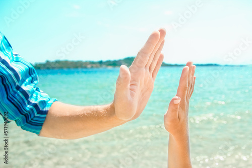 A Hands of a happy parent and child in nature by the sea on a journey background