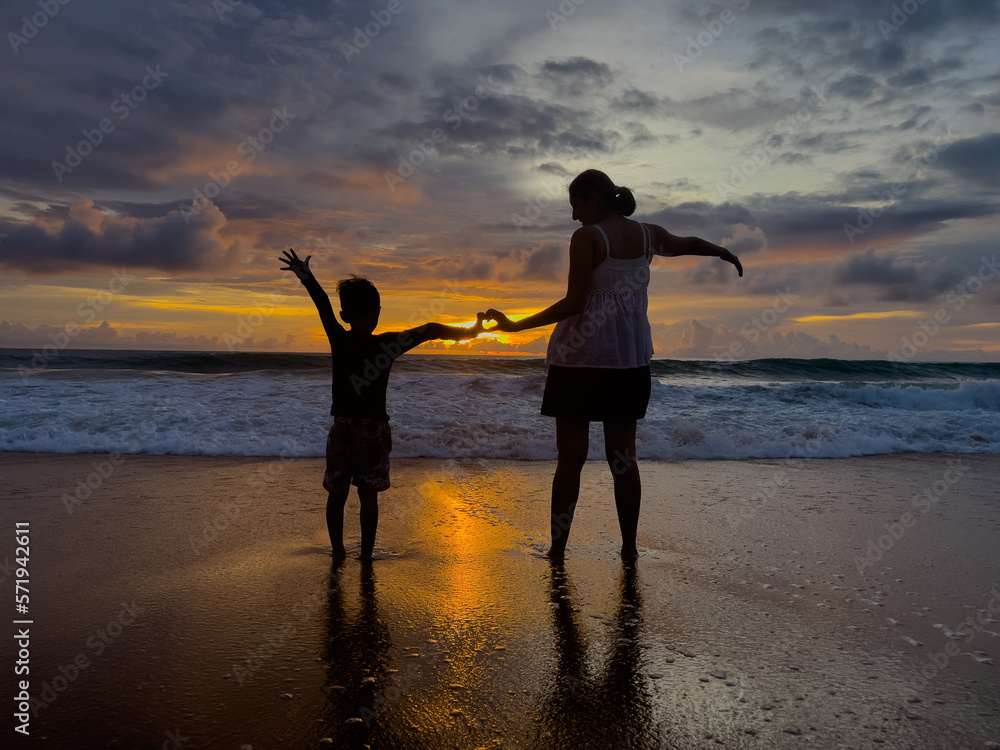 Fototapeta premium Mother and daughter take a walk on the beach in the evening.