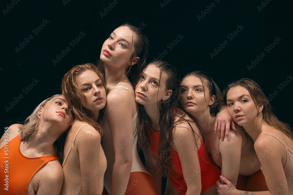 Youth, beauty, attraction. Group of young beautiful girls in bodysuits posing over black studio background. Contemporary dance style. Concept of art, movement, youth, fashion, artistic lifestyle