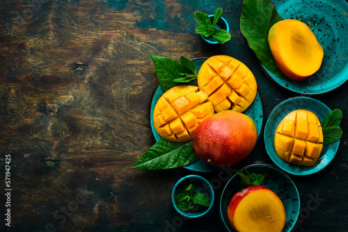 Fototapeta Naklejka Na Ścianę i Meble -  Mango background. Fresh delicious sweet mangoes in a plate. Top view. Copy space.