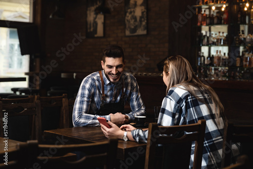 Foto Young colleagues bartenders and waitress sit at the bar and get bored while the