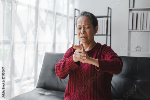 Elderly asian housewife woman sitting on sofa. finger pain