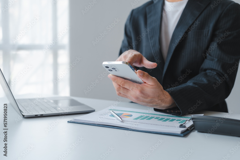 Fototapeta premium Young handsome asia business man in formal suit working with monthly report balance sheet and yearly tax of accounting to verify the account by an authorized auditor