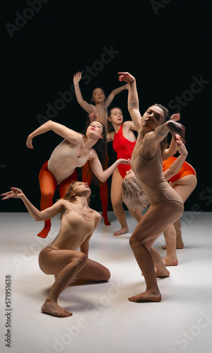 Aesthetics of dance art. Young creatie girls performing contemporary, experimental dance on stage on black background. Concept of movement, youth, fashion, artistic lifestyle, flexibility, inspiration