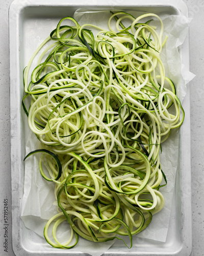 Zucchini Noodles Called Zoodles Freshly Spiralized on a White Parchment Sheet-Pan  photo