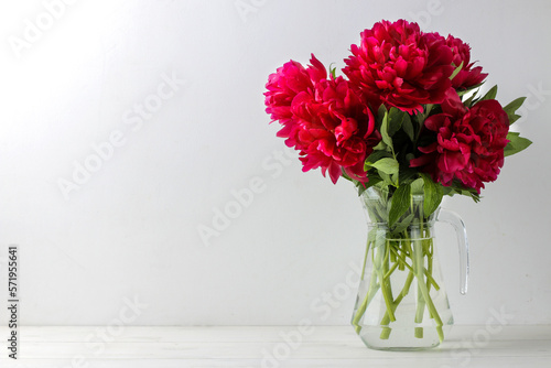 Fototapeta Naklejka Na Ścianę i Meble -  Beautiful bright pink flowers peonies in a jug on a light background. space for text