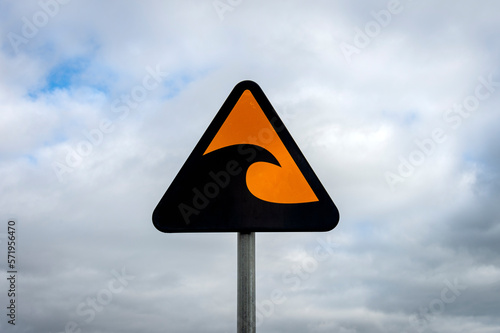 tsunami warning sign against a cloudy sky