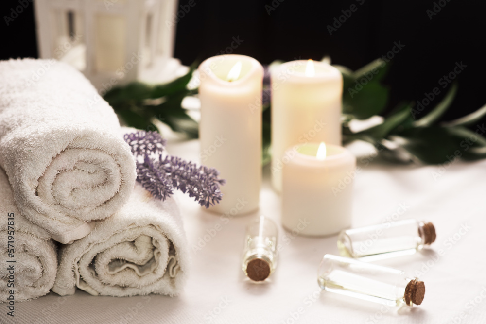Spa still life with aromatic candles,oils and towel. Dark background Spa still life with aromatic candles,oils and towel. Dark background