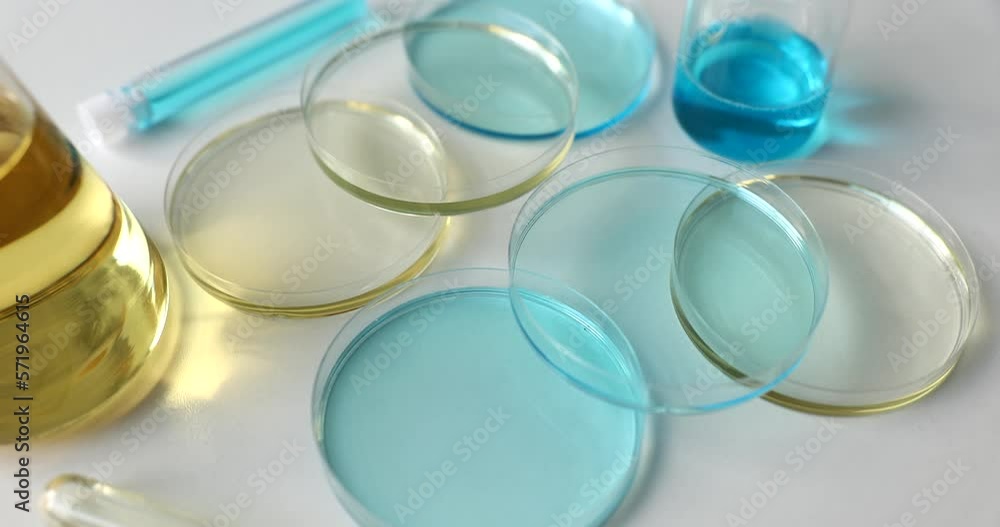 Various glassware and test tubes with light blue liquid and oil in laboratory Various glassware and test tubes with light blue liquid and oil in laboratory