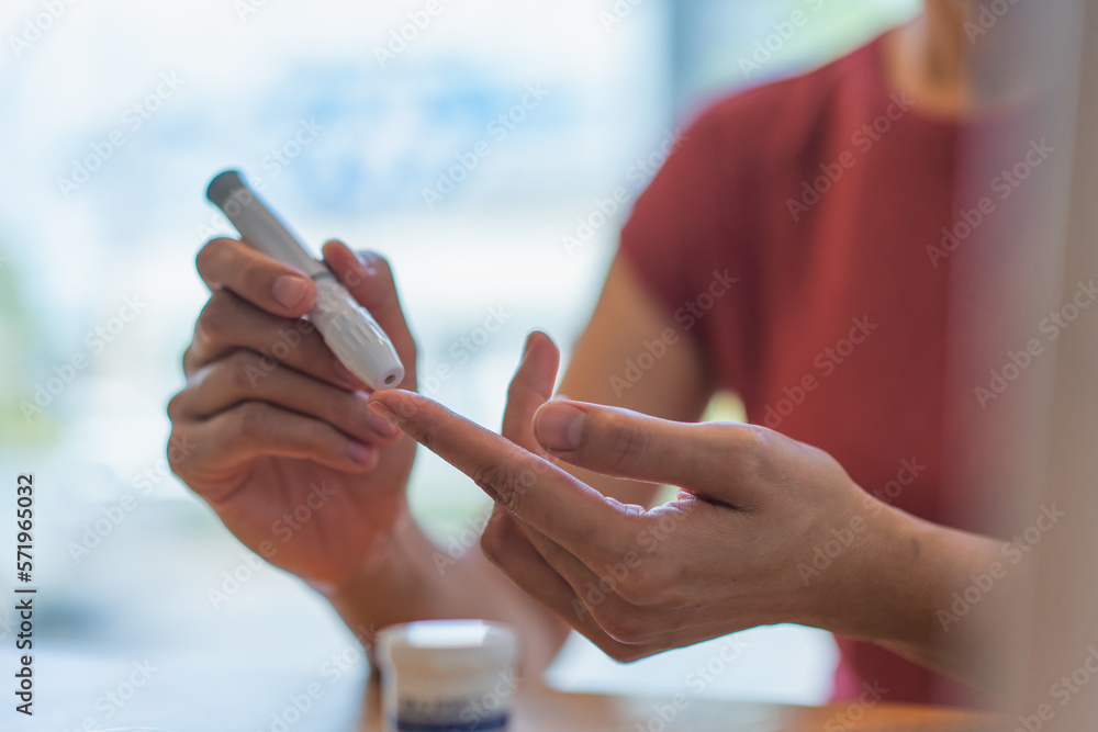 young woman using blood test kit at home while doing health check . home finger prick blood test . close up, diabetes concept, elderly health care, young woman using blood test kit at home while doing health check . home finger prick blood test . close up, diabetes concept, elderly health care,