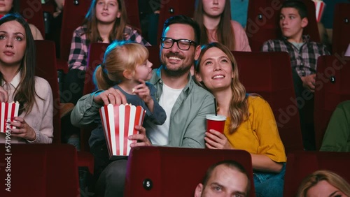 Couple with child in movie theater.