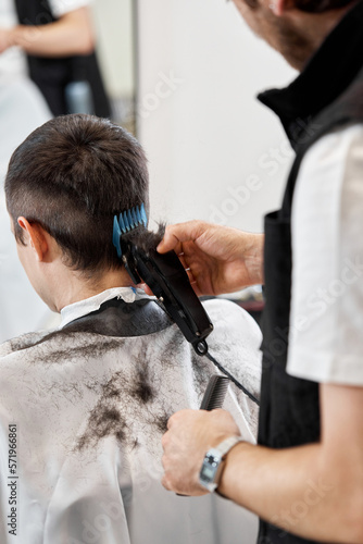 Barber shaving caucasian man in barber shop.