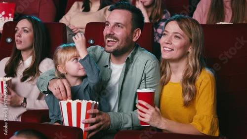 Young family watching movie in theater.