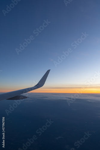 Beautiful sunset, sky on the top view, airplane flying view from inside window aircraft of Traveling.. Sunlight and flare background concept.