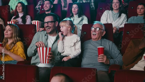 Grandfather, son and granddaughter in movie theater.