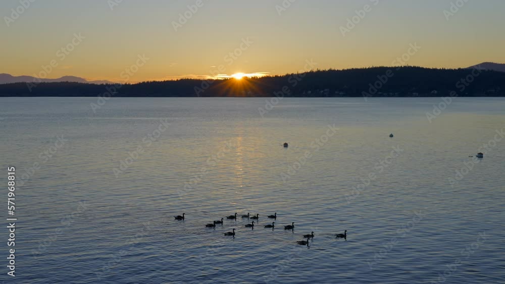 Establishing shot of ocean sunset over mountains in slow motion at summer day in Vancouver, Canada, North America. Evening time on September 2022. Still camera. ProRes 422 HQ. Establishing shot of ocean sunset over mountains in slow motion at summer day in Vancouver, Canada, North America. Evening time on September 2022. Still camera. ProRes 422 HQ.