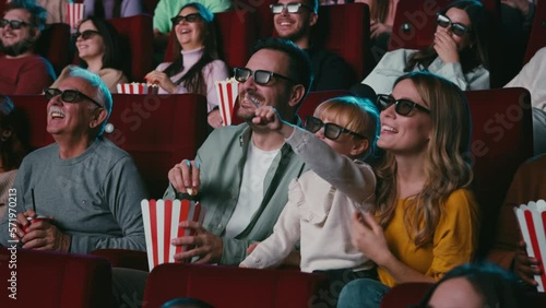 Cheerful family with 3D glasses in cinema.