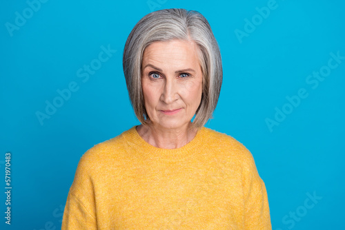 Photo portrait of stunning grandma look raise brow suspicious unsure look dressed stylish yellow clothes isolated on blue color background