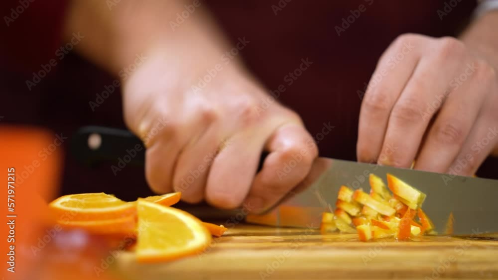Man slicing orange fruit. Man's hand quickly cutting orange. Angry, nervous man in kitchen cutting fruits with professional knife.
Man slicing orange fruit. Man's hand quickly cutting orange. Angry, nervous man in kitchen cutting fruits with professional knife.