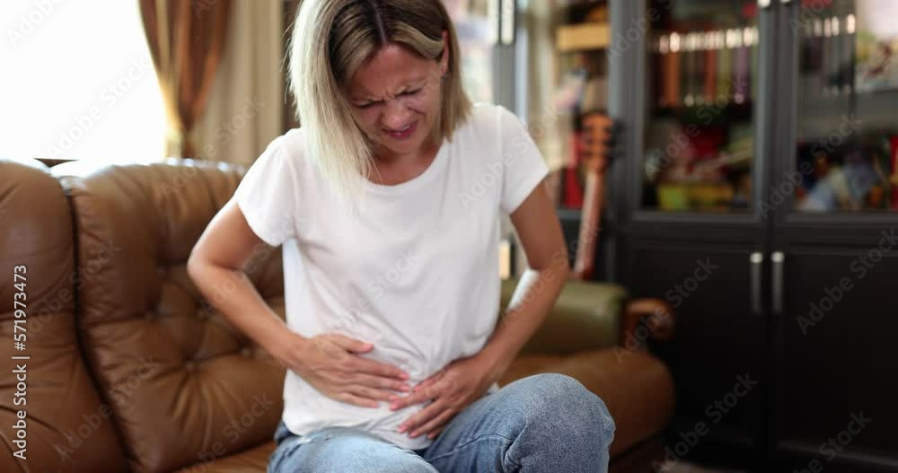 Beautiful woman with severe abdominal pain at home