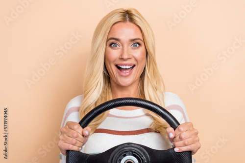Photo of impressed lovely funny woman with curly hairstyle striped long sleeve hold steering wheel isolated on pastel color background