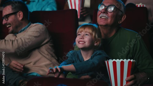 Cheerful girl with grandfather at movies.