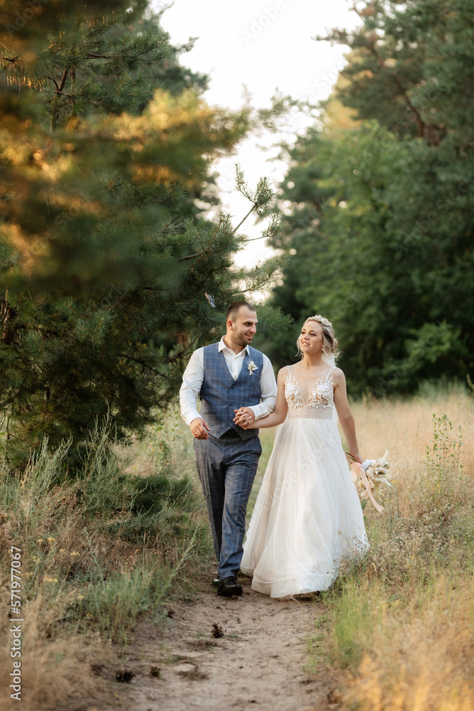 the groom and the bride are walking in the forest the groom and the bride are walking in the forest