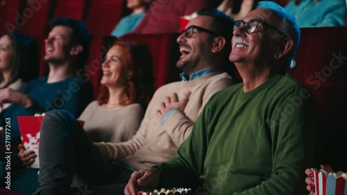Joyful senior watching movie in cinema.
