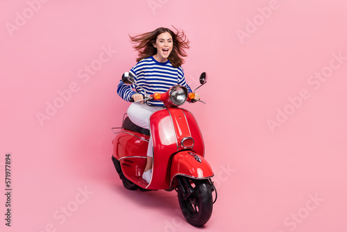 Full body photo of overjoyed positive lady drive moped have good mood isolated on pink color background