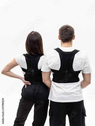 Woman and man in black posture correctors on white background. Straight back