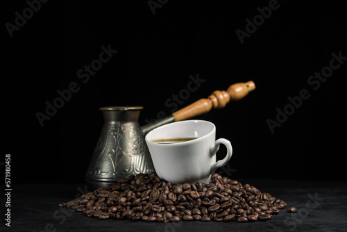 A cup of espresso coffee on coffee beans. Cup of natural coffee on a black background