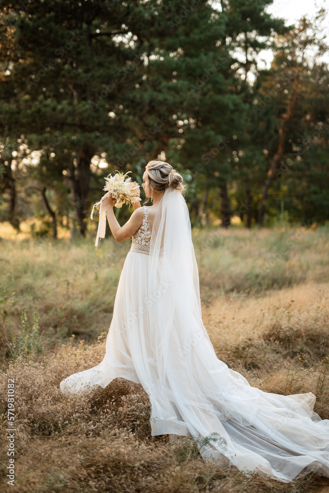 bride blonde girl with a bouquet in the forest